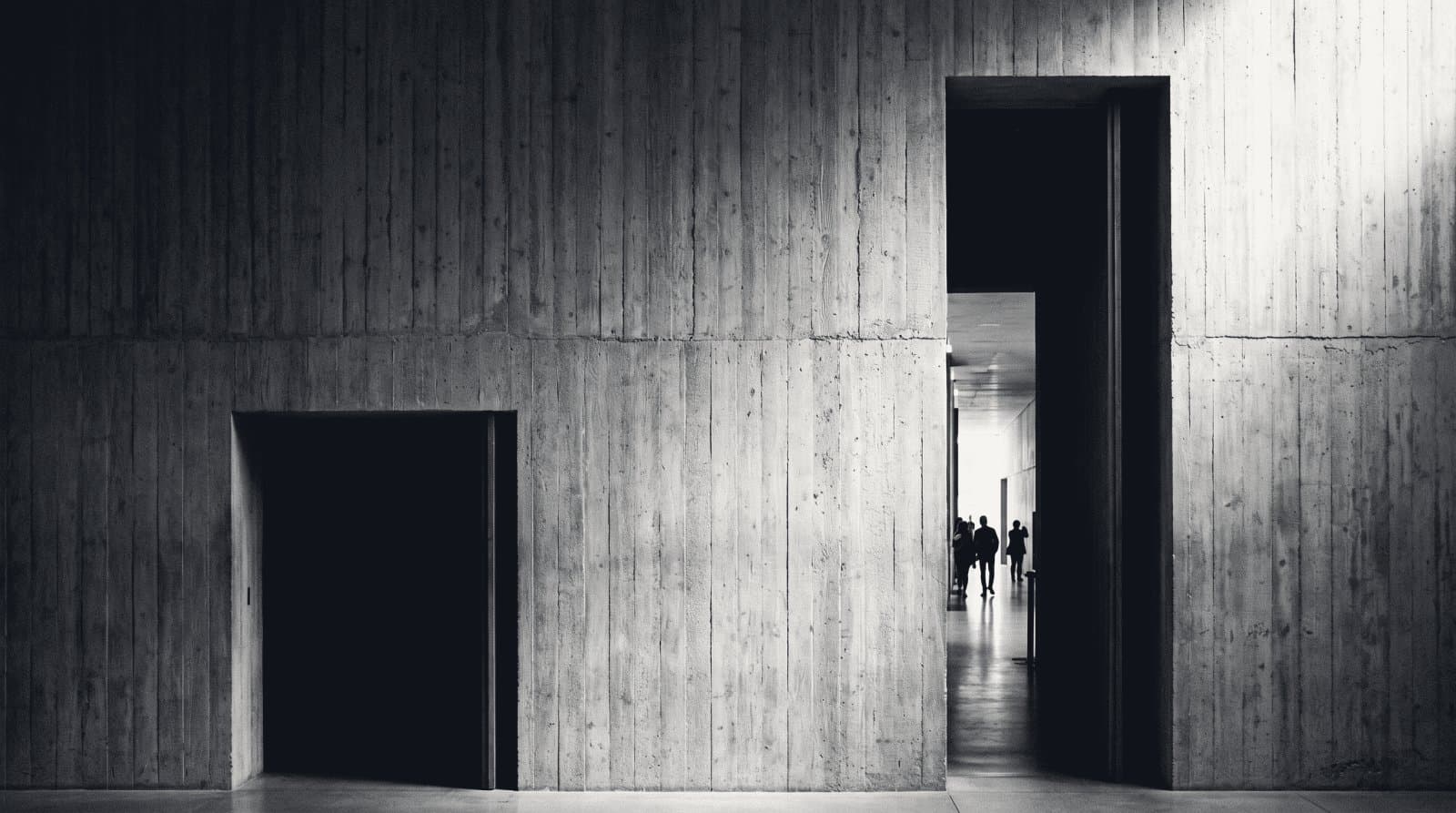 Two adjacent openings of unequal size in a plain wall, each giving onto different light.